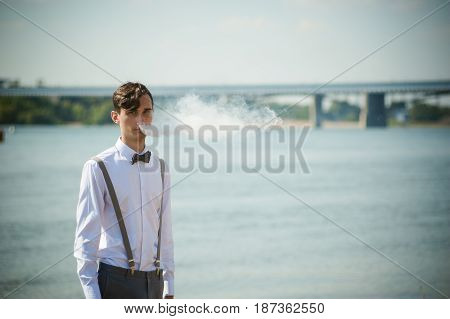 Young Skinny Man, Elegantly Stylishly Dressed In White Shirt, Trousers With Suspenders And Bow Tie.
