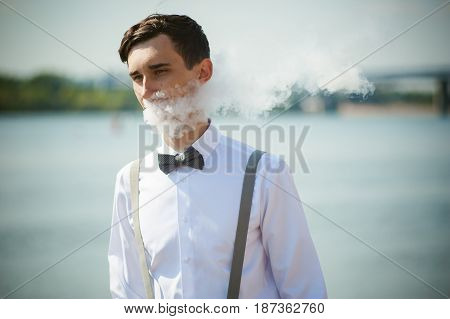 Young Skinny Man, Elegantly Stylishly Dressed In White Shirt, Trousers With Suspenders And Bow Tie.