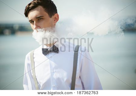 Young Skinny Man, Elegantly Stylishly Dressed In White Shirt, Trousers With Suspenders And Bow Tie.