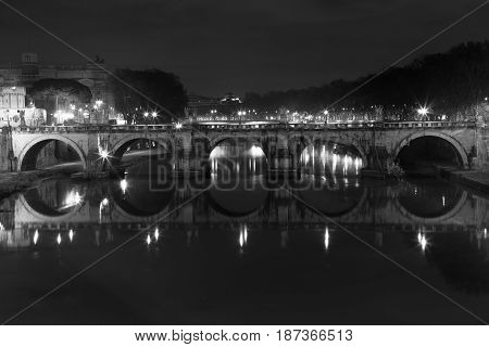 Ponte Sant Angelo, bridge in Rome at night time. Italy. Black and white. Once the Aelian Bridge or Pons Aelius, meaning the Bridge of Hadrian, is a Roman bridge in Rome, Italy.