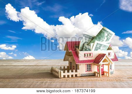 Wooden Model House With Money Inside On Wood Table With Copy Space Ready For Your Design.