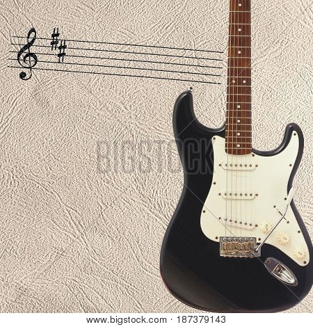 Notes and solid body classic electric guitar on the right side of the light skin background.