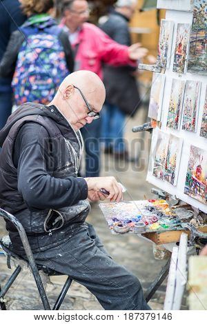 Paris, France - May 12, 2017: An artist painting on Place du Tertre in Montmartre district in Paris