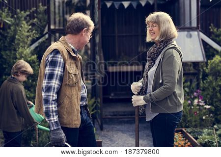 Senio couple with little boy gardening at home backyard