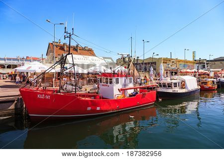 HEL POLAND - AUGUST 10 2015: People walking through in the port on the waterfront with many boat and sailboat in Hel. Hel is one of most famous cruise travel destinations in Poland.