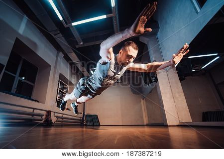 Attractive Muscular Man Doing Push-ups On A Wooden Floor.