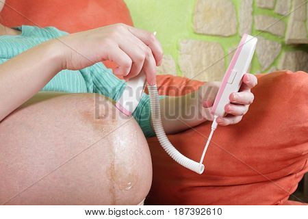 Pregnant woman with the help by a fetal doppler controls a condition of a fetus.