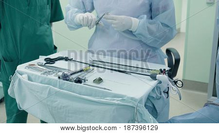 Laparoscopic surgery of the abdomen. The surgical nurse prepares the medical instrument
