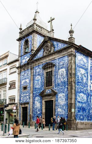 PORTO PORTUGAL - MARCH 11 2017: Chapel of Souls (Capela das Almas) church tiled facade in Rua de Santa Catarina at city old town. The painted enameled azulejos are an element of Portuguese culture.