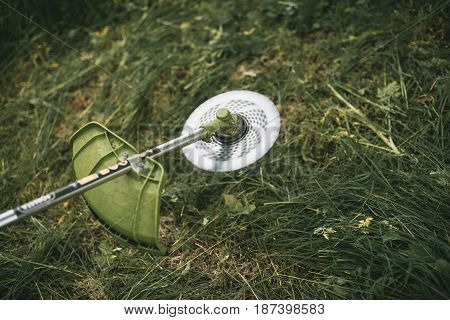 Gasoline Trimmer Head On Green Grass. Round Trimmer Blade.