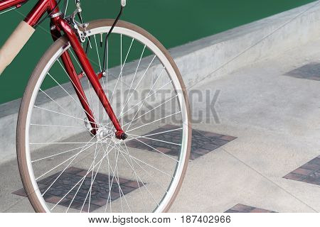 Closeup bicycle wheels on the cement floor and close to the green flap.