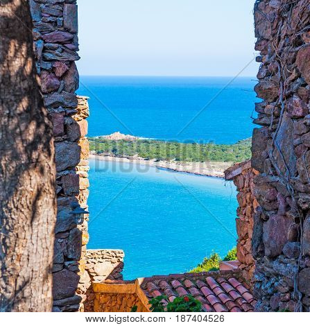 Capo Coda Cavallo shore seen through a rustic wall Sardinia