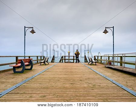 Man On Mole, Autumn Misty Morning. Tourist At Handrail.