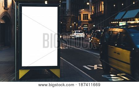 Blank advertising light box on bus stop mockup of empty ad billboard on night bus station template banner on background city street for message or text in Barcelona afisha board and headlights of taxi cars