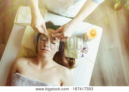 Lifting face massage with sugar gel. Beautiful young woman getting a face treatment at beauty salon.