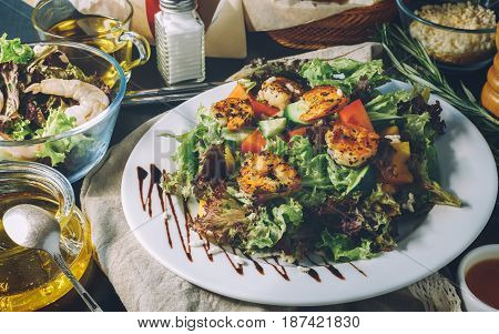 The concept making tasty and healthy food at home. Ingredients and cutlery around fresh salad with shrimps. Serving option
