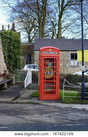 WADDINGTON, UK - FEBRUARY 4, 2017: A emergency defibrillator being used in a old style UK red phone box in the small village of Waddington, Lancashire, UK