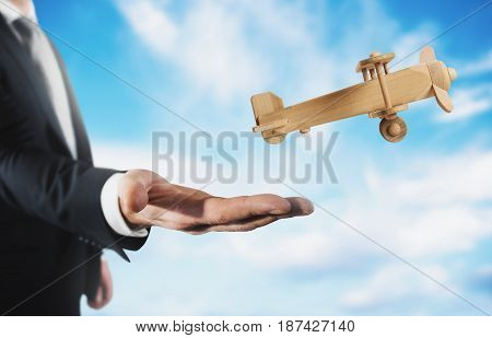 Businessman holding a small wooden aircraft. Startup working enterprise concept