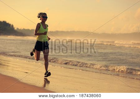 healthy lifestyle young fitness woman running on sunrise beach