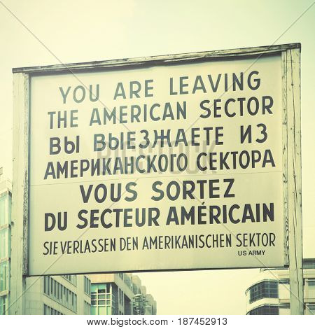 You are leaving the american sector - Historic sign near The Checkpoint Charlie in Berlin, Germany. Retro style