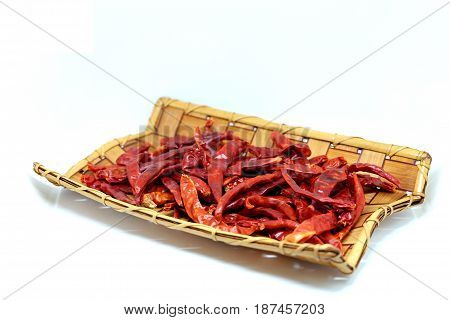 Dried red chilies, hot red pepper in the wood basket isolate on white background