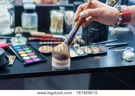 Table of professional visagiste with brushes for make up and instruments for visage. Makeup kit
