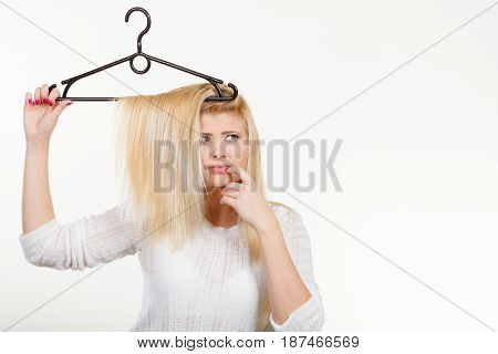 Blonde Woman Holding Hair On Clothes Hanger