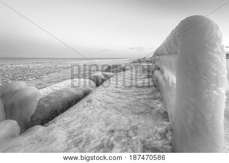 Deep Freeze. Ice covered pier juts into the icy waters of Lake Huron during a Great Lakes deep freeze. Lexington, Michigan.