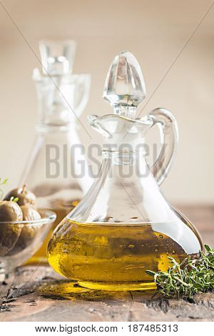 olive oil in glass bottle and olives over old wooden table