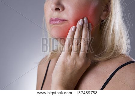 Aged woman with toothache teeth pain closeup on gray background