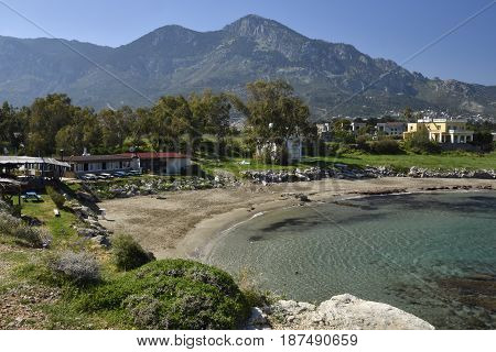 Bay with a beach near Lapta village with clear blue water and blue sky and Kyrenia mountains in the North of Cyprus in background.