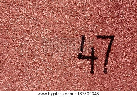 Number Fourty Seven On Red Plaster Wall.
