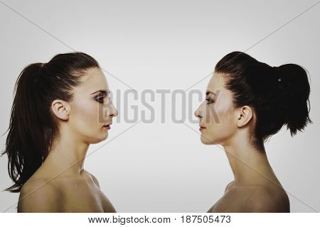 Two sisters standing face to face.