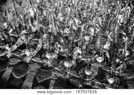 Lots Of Clean Empty Glasses Of Drinks On The Bar In A Nightclub. Glare And Reflections On The Glasse