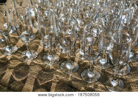 Lots Of Clean Empty Glasses Of Drinks On The Bar In A Nightclub. Glare And Reflections On The Glasse