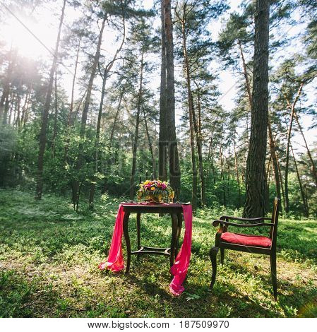 Decorated Wooden Table Served For Two In The Garden On Grass On The Riverbank. Boho And Rustic Style