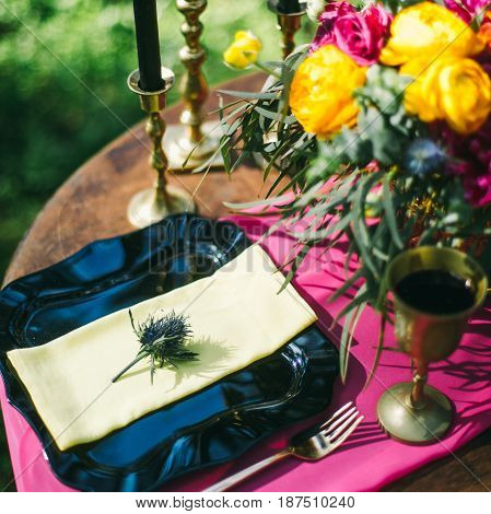 Decorated Wooden Table Served For Two In The Garden On Grass On The Riverbank. Boho And Rustic Style