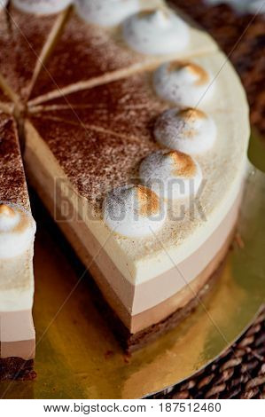 four layer cake with shades of brown. Here cream to chocolate.