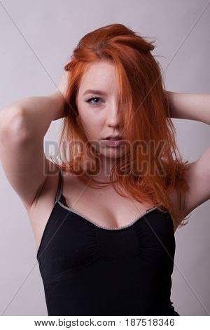 Beautifu hotl busty woman in studio photo on gray background. Sexuality and sensuality. Attractive model
