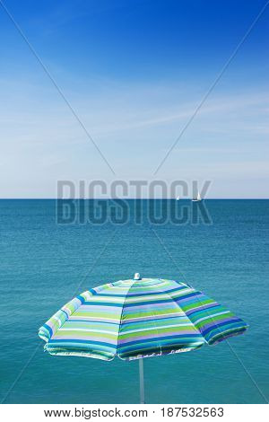 Beach blue umbrella against the sea - Image with copy space