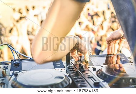 Close up of dj playing electro sound on modern cd usb player at summer beach party - Music festival and entertainment concept - Defocused background with shallow depth of field - Focus on mixing hand