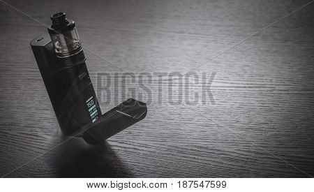 Black Vaporizer On The Brown Wooden Table