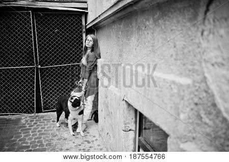 Trendy Girl At Glasses And Ripped Jeans With Russo-european Laika (husky) Dog On A Leash, Against St