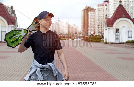 Young man with a skateboard on the street of a big city