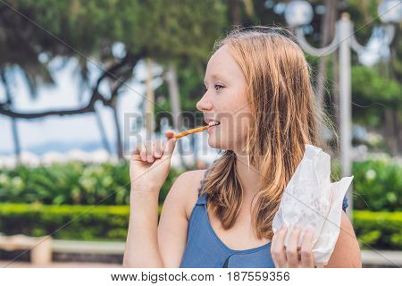 Women Eat Fried Sweet Potatoes In The Park. Junk Food Concept