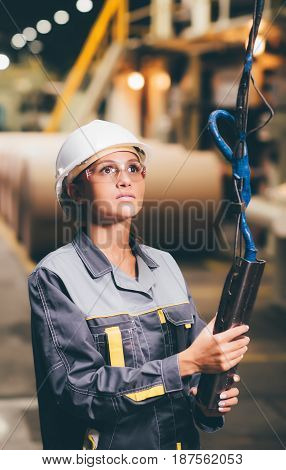 woman operating crane at paper mill factory