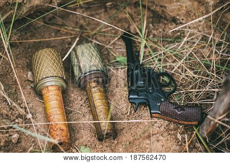 Soviet Red Army Russian Soldiers Military Ammunition Of World War II On Ground. Two Grenades And Nagant Handgun Gun.