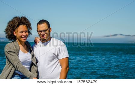Brother and sister poses with Golden Gate Bridge in background view