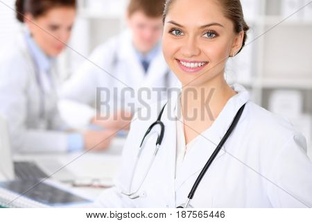Happy doctor woman  with medical staff at the hospital sitting at the table and discussing medical history