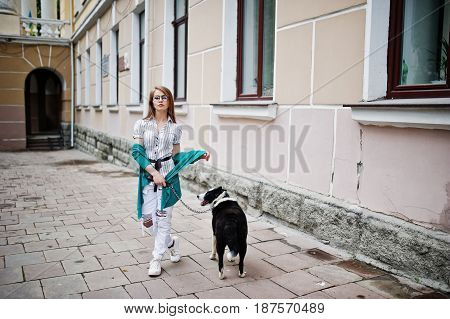 Trendy Girl At Glasses And Ripped Jeans With Russo-european Laika (husky) Dog On A Leash, Against St